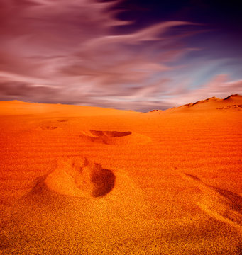 Footprints on sand dune, Sahara Desert sunset,
