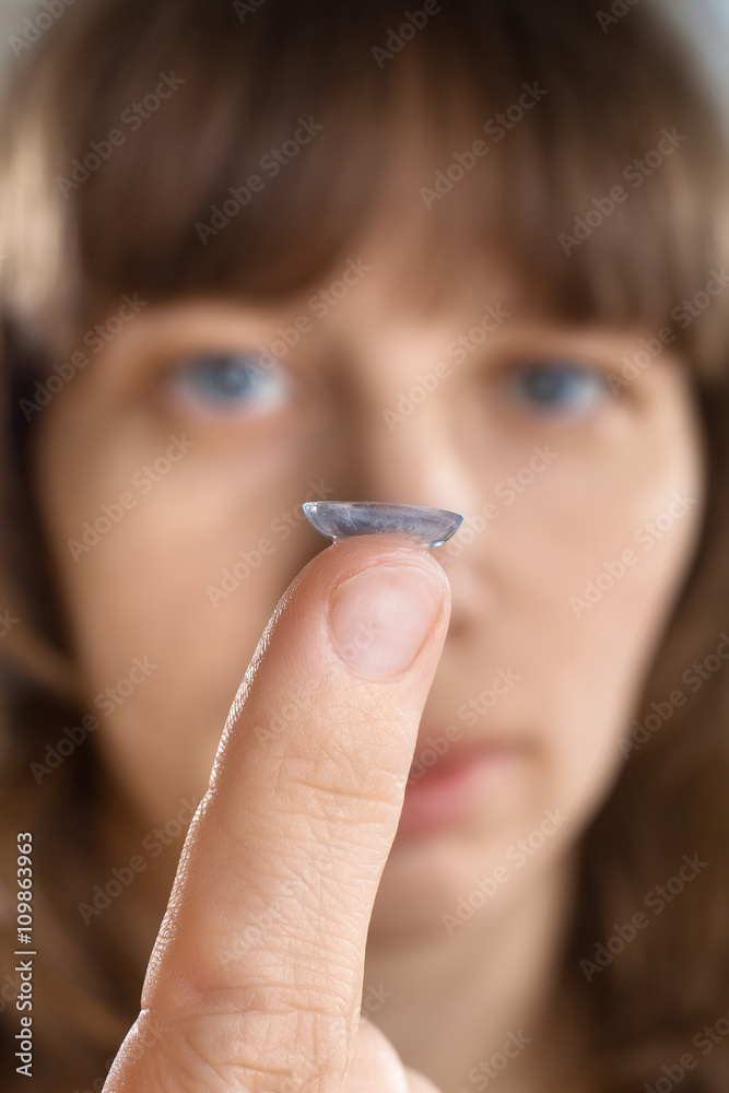 Wall mural contact lens on finger of woman (selective focus used)