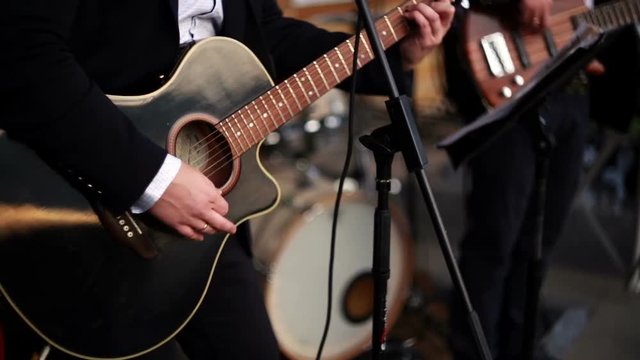 Guitarist playing an acoustic guitar.