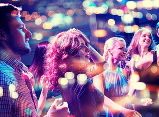smiling friends dancing in club