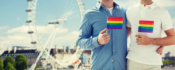 close up of male gay couple with rainbow flags