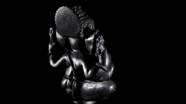 Ganesha, Hindu deity figure, turning on black background