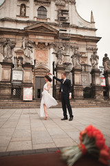 Bride and groom on the background of beautiful church. Beautiful old building. Arch. Wedding