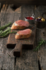 Fototapeta premium Bruschetta with salami, olives and rosemary
