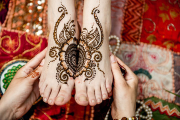 Young beautiful woman with mehendi. Feet close up