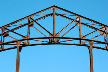 Fototapeta premium Detail of old rusty metal bridge on blue sky background