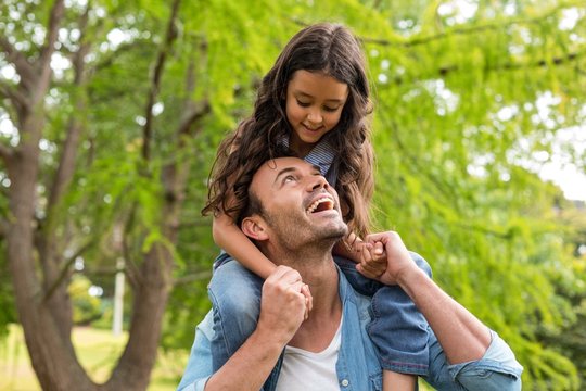 Father Carrying Daughter On His Shoulders