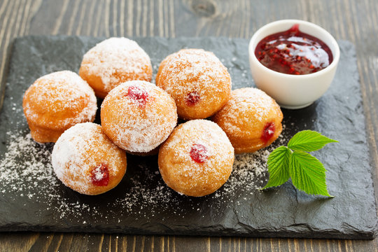Donuts filled with raspberry jam and powdered sugar in.