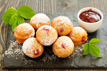 Donuts filled with raspberry jam and powdered sugar in.