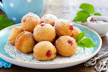Donuts filled with raspberry jam and powdered sugar in.