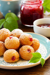 Donuts filled with raspberry jam and powdered sugar in.