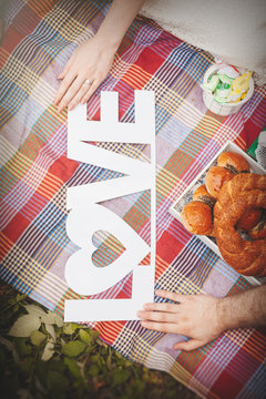 Engagement couple holding love letters on picnic