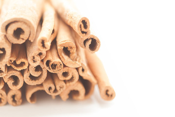 Artistic view of Raw Organic Cinnamon sticks (Cinnamomum verum) isolated on white background.