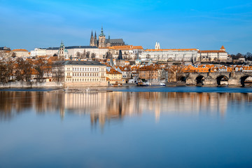 Obraz premium Charles Bridge, St. Vitus Cathedral and other historical buildings in Prague reflected in the river. This image is toned.