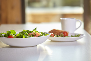 Fresh vegetable salad isolated on white table in kitchen