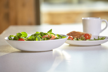 Fresh vegetable salad isolated on white table in kitchen