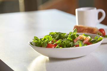 Fresh vegetable salad isolated on white table in kitchen
