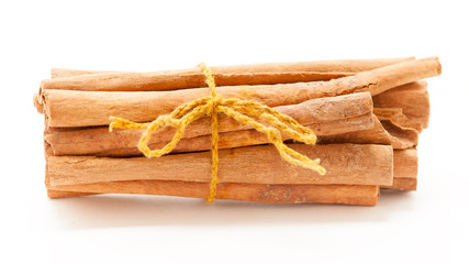 Top view of Raw Organic Cinnamon sticks (Cinnamomum verum) bundle tied up with turmeric colored  thread.