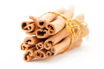 Front side view of Raw Organic Cinnamon sticks (Cinnamomum verum) bundle tied up  with turmeric colored  thread.