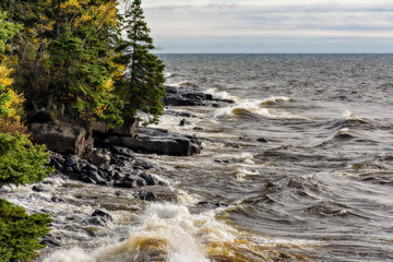 Waves crashing on the Lake Superior shoreline reveal the amber tanin stains brought to the lake by numerous rivers along the north shore in Minnesota.