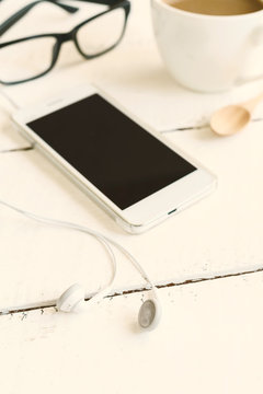 cellphone and earphone with a cup of coffee