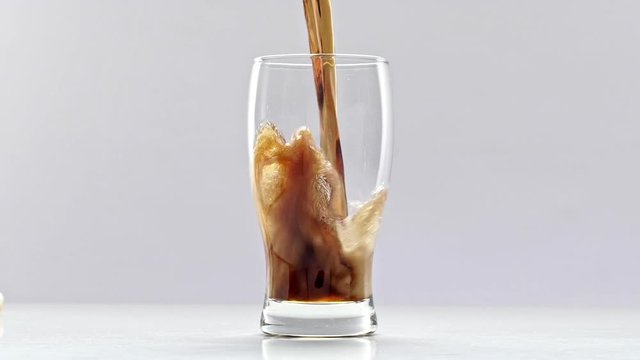 Pouring soda in glass. Slow motion