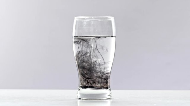 Ink drop poured in a glass with water. 