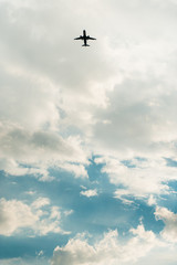 airplane flying in the blue sky with clouds