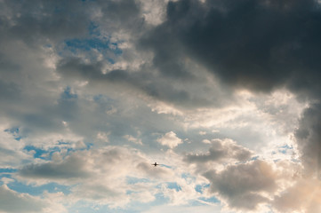 airplane flying in the blue sky with clouds