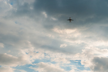 airplane flying in the blue sky with clouds