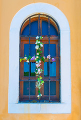 Fototapeta na wymiar Finestra di una chiesetta decorata con fiori