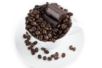 stack of beans in coffee cup with chocolate bar.