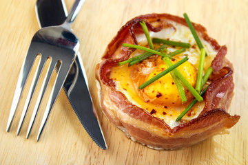 Oven roasted bacon wrapped egg with utensils