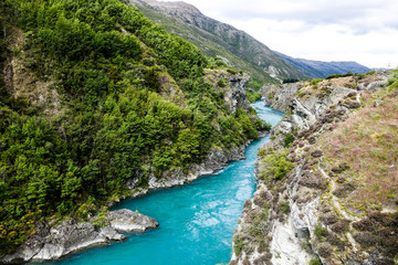 Fototapeta na wymiar Blue water river flowing in New Zealand close to the Kawarau Bridge Bungy, in Queenstown