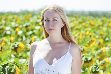 Portrait of a beautiful young blonde woman in a white dress on a