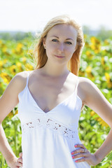 Fototapeta premium Portrait of a beautiful young blonde woman in a white dress on a
