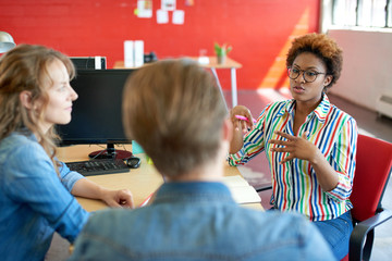 Unposed group of creative business people in an open concept office brainstorming their next...