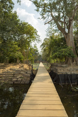 Fototapeta na wymiar Wooden path to Neak Pean temple near Angkor Wat. Cambodia