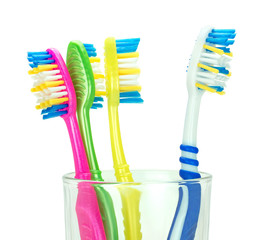 Четыре зубные щетки в стеклянном стакане