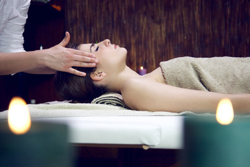Woman getting head massage in relaxing spa sleeping