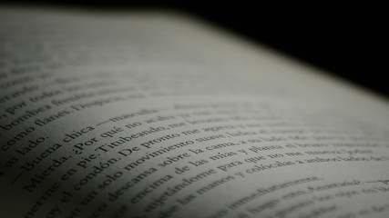 Texts of a open book written in spanish rotating