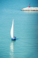 Lonely seaman with little sailboat