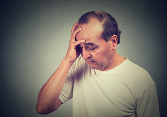 portrait of middle aged desperate man isolated on gray wall background