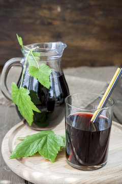 Glass and jug with fresh Black Currant juice decoration fresh currant leaves