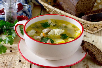 Soup with dumplings and meat on wooden table, selective focus.