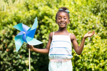 Cute mixed-race girl smiling and holding a windmill
