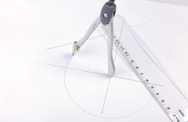 pair of compasses drawing circle on a paper