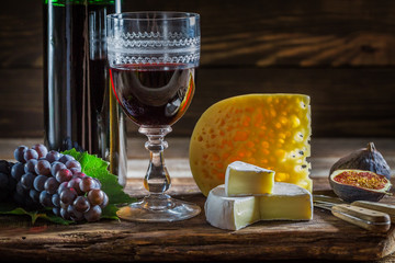 Red wine with various types of cheese and grapes