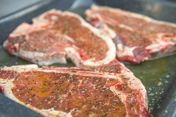 thick raw t-bone steak with seasoning