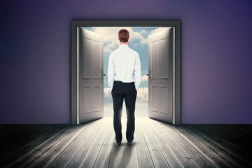 Obraz premium Composite image of rear view of businessman with hands in pocket